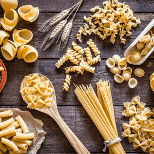 Assorted pasta varieties on wooden table