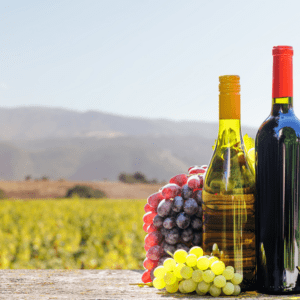 Grapes and wine bottles on wooden table