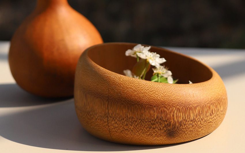 Round wooden bowl with small white flowers